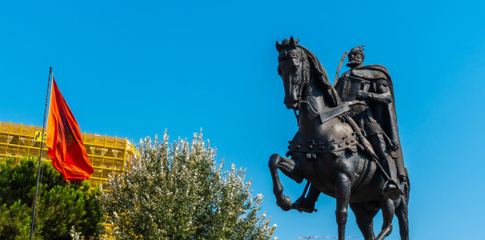 The beautiful Skanderbeg horse monument in Skanderbeg Square in Tirana and the red flag of Albania